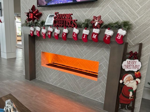 A fireplace with christmas stockings and a sign that says merry christmas