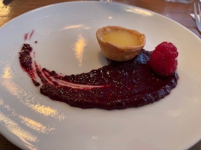 A white plate topped with a dessert and a raspberry