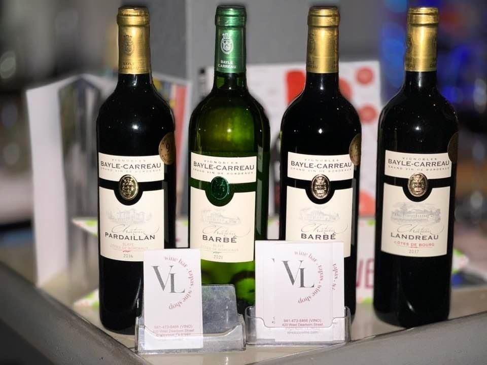 Four bottles of wine are sitting on a table.