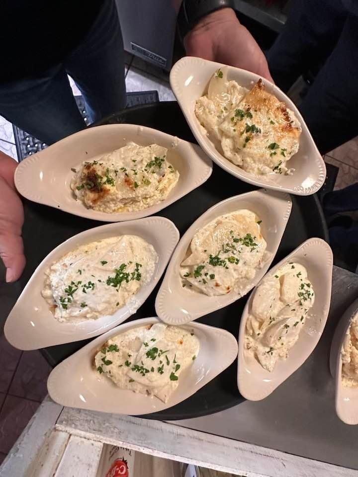 A person is holding a tray of food on a table.