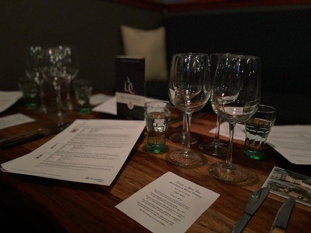 A table with a menu and wine glasses on it