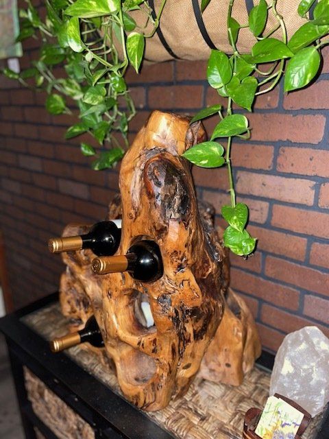 A wooden wine rack is sitting on a table in front of a brick wall.