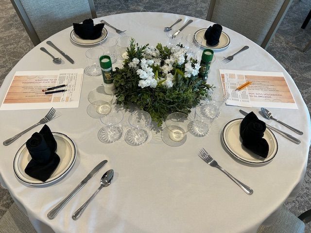 A table with plates , silverware and a centerpiece of flowers