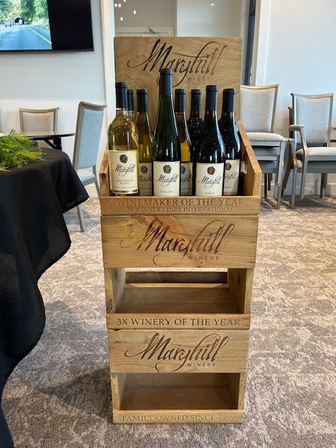 A display of wine bottles in wooden crates in a room.