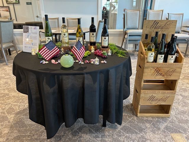 A table with bottles of wine and american flags on it.