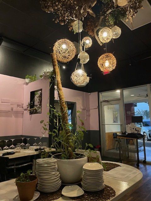 A restaurant with plates and potted plants on the counter
