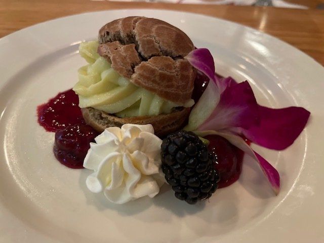 A dessert with whipped cream and berries on a white plate
