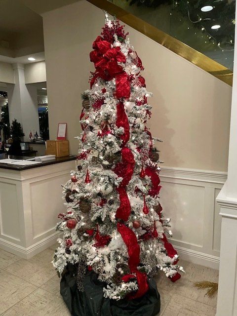 A white christmas tree with red and silver decorations