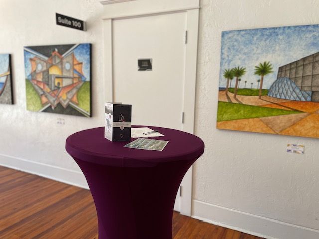 A purple table in a room with paintings on the wall