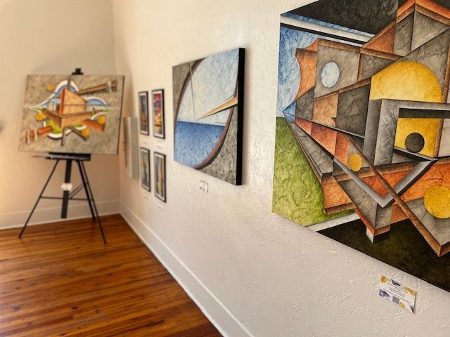 A room with paintings on the wall and a wooden floor