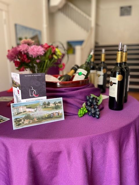 A table with bottles of wine and flowers on it