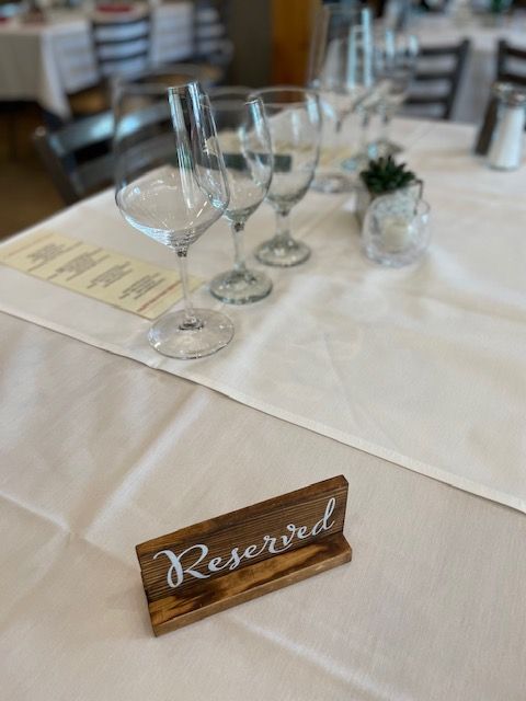 A wooden sign on a table that says reserved