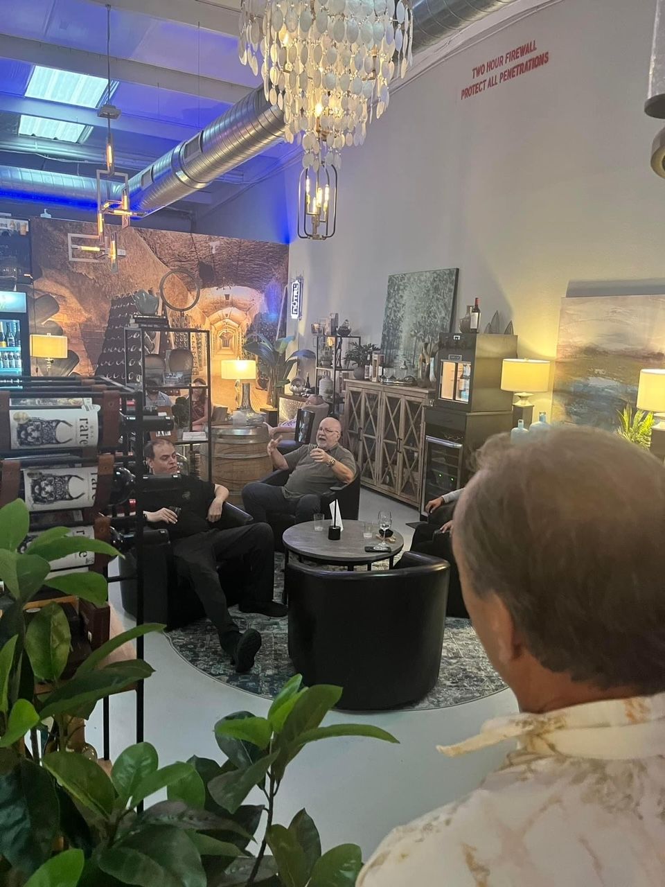 A man is looking at a group of people sitting in chairs in a room.