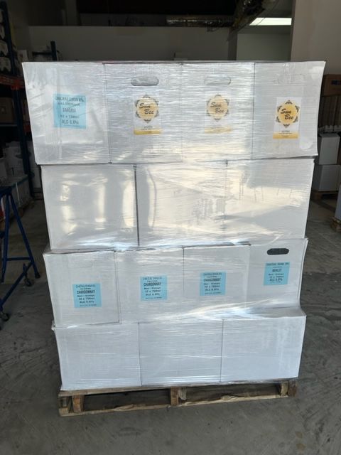 A pallet of boxes wrapped in plastic is stacked on top of each other.