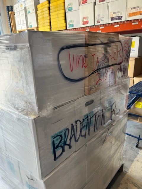 A bunch of boxes are wrapped in plastic and stacked on top of each other.