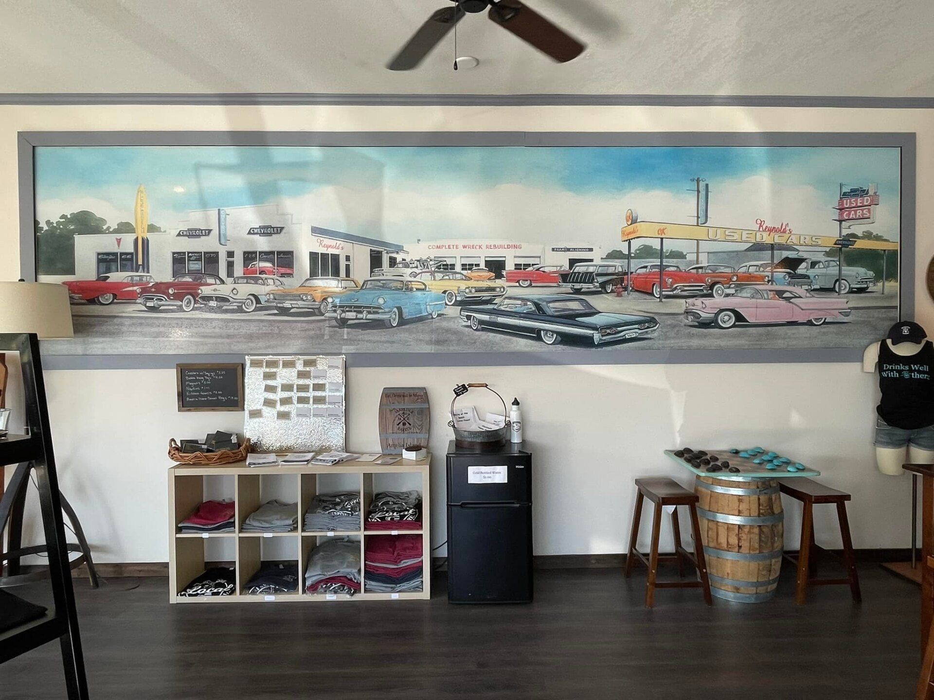 A room with a large painting of cars on the wall