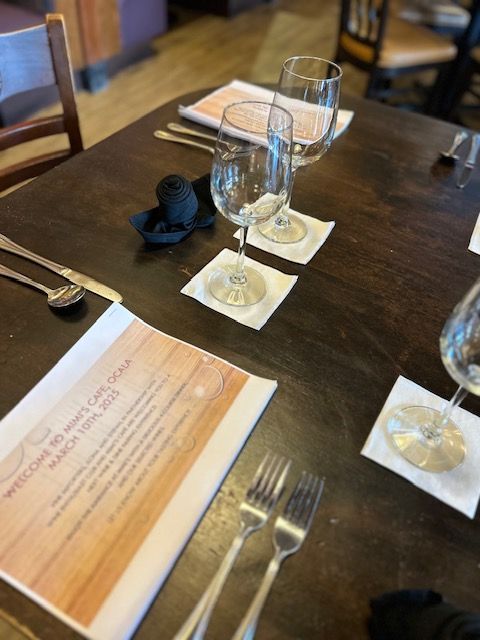 A wooden table with a menu and wine glasses on it