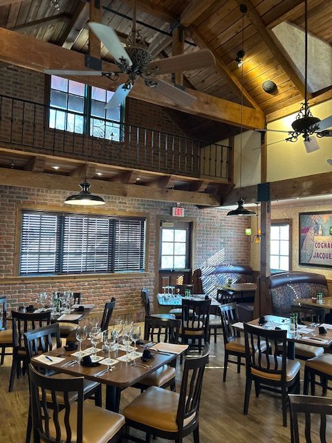 A restaurant with tables and chairs and a ceiling fan