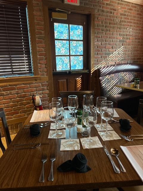 A restaurant with a table set with wine glasses and silverware