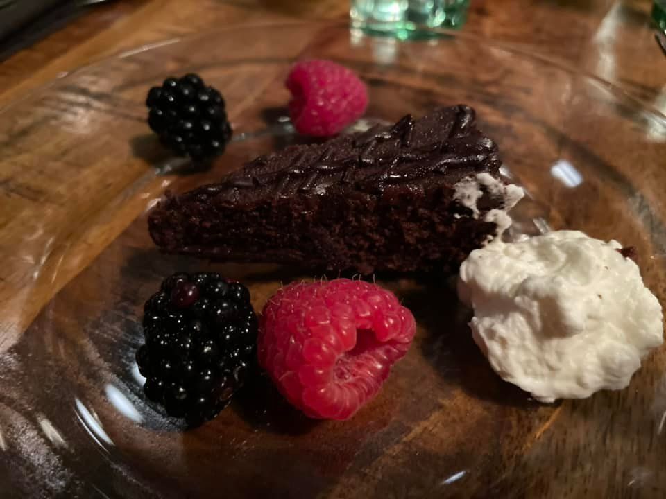 A piece of chocolate cake with raspberries and blackberries on a plate