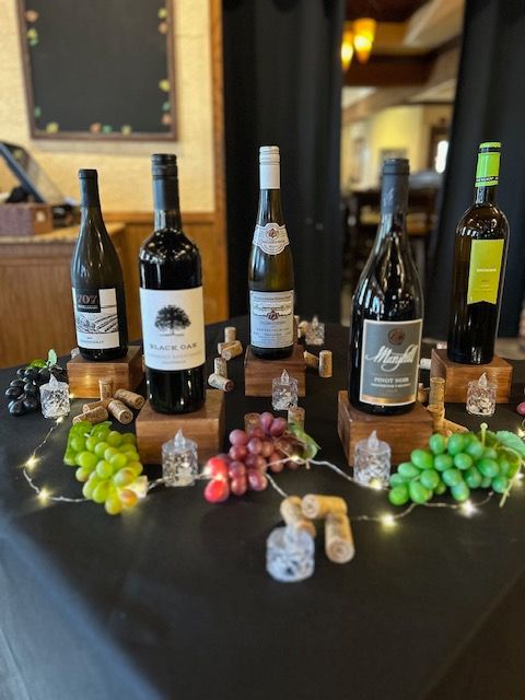 A table with bottles of wine and grapes on it