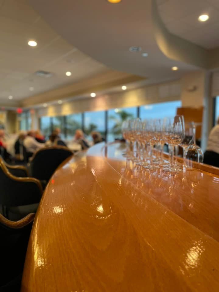 A row of wine glasses sitting on a wooden bar in a restaurant.