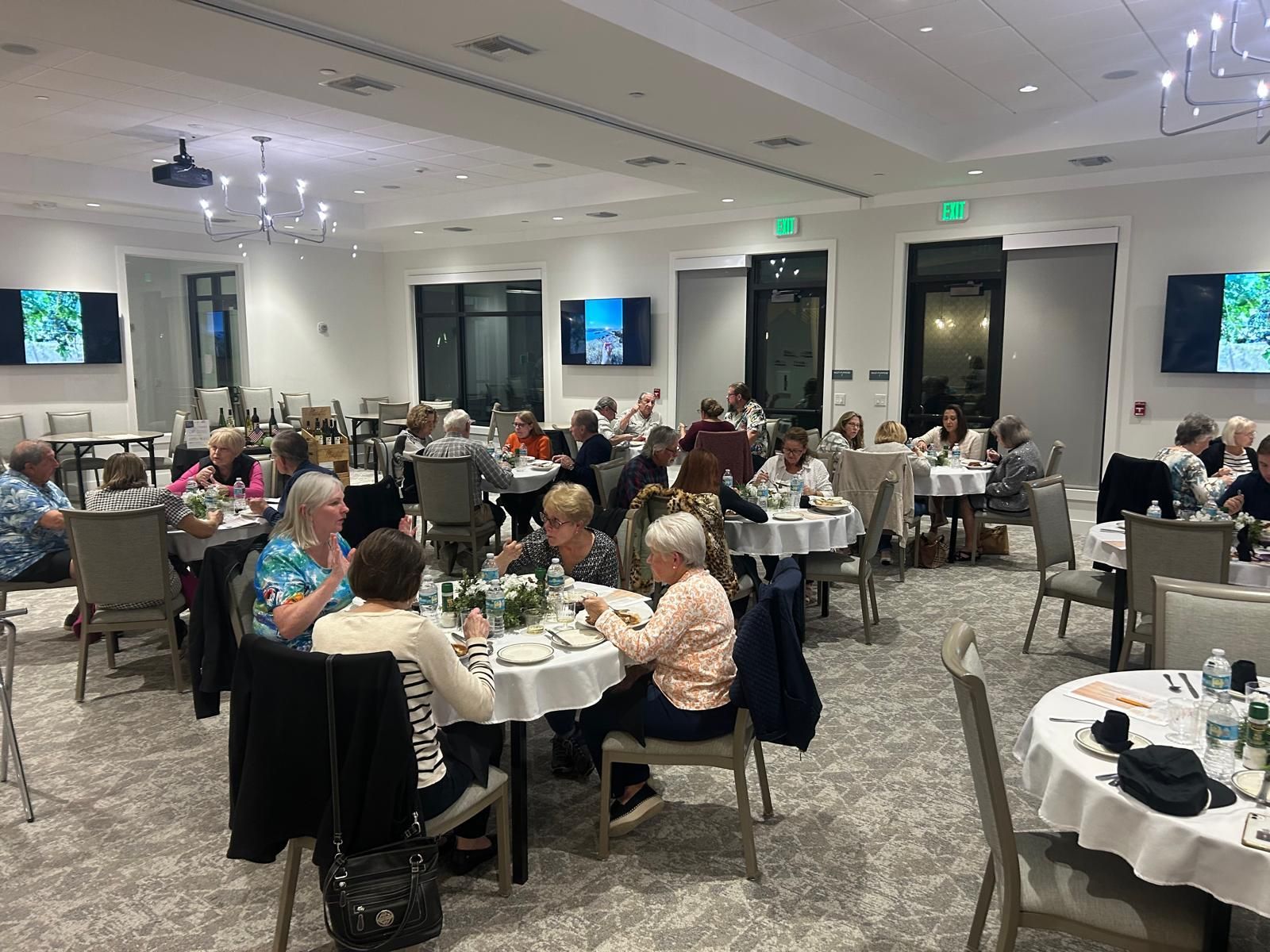 A large group of people are sitting at tables in a large room.