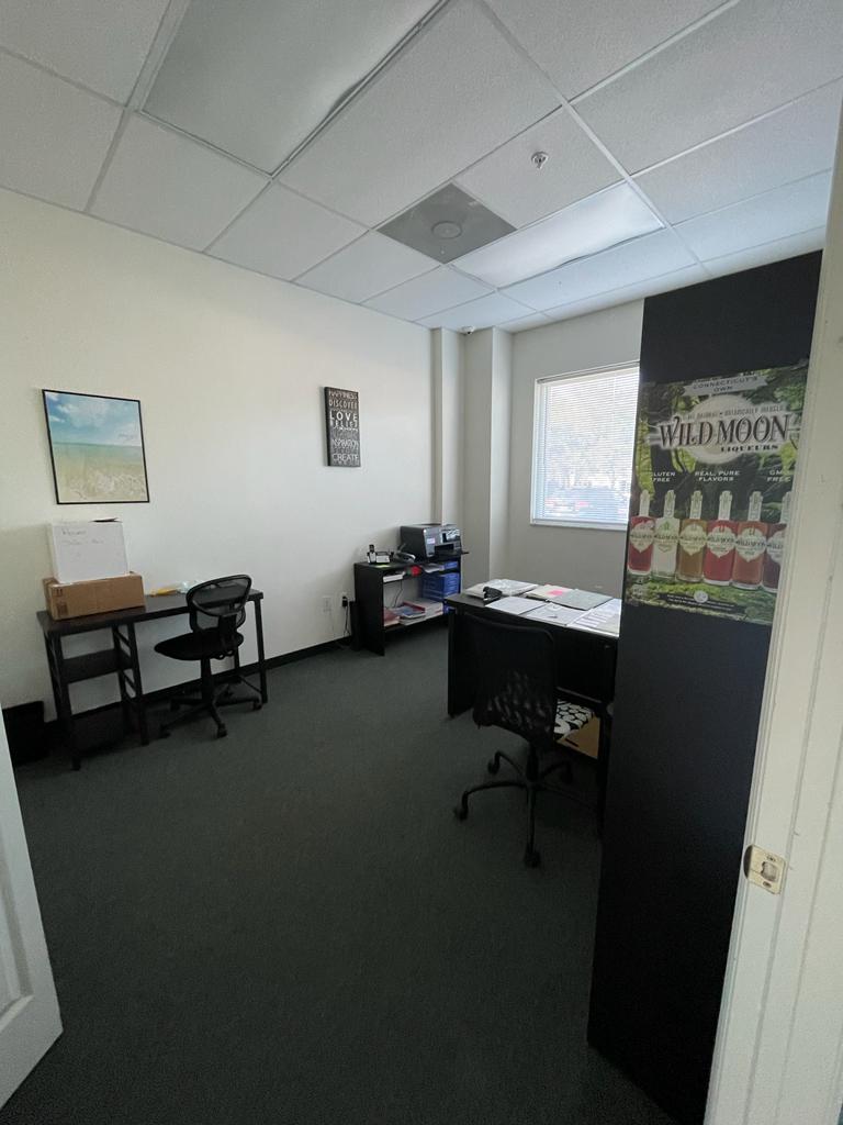 A small office with a desk and chairs in it.