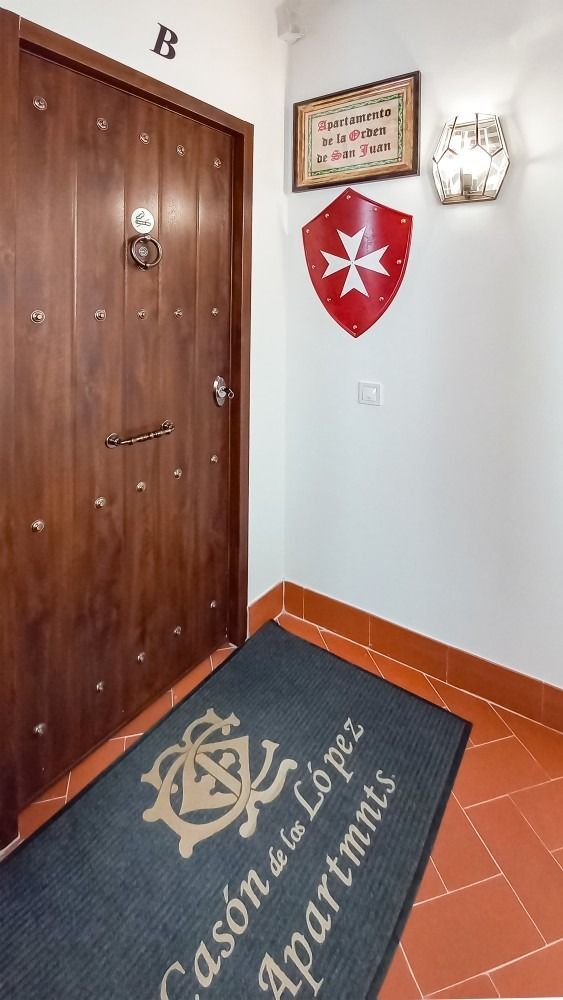 A doorway with a mat in front of it and a shield on the wall.