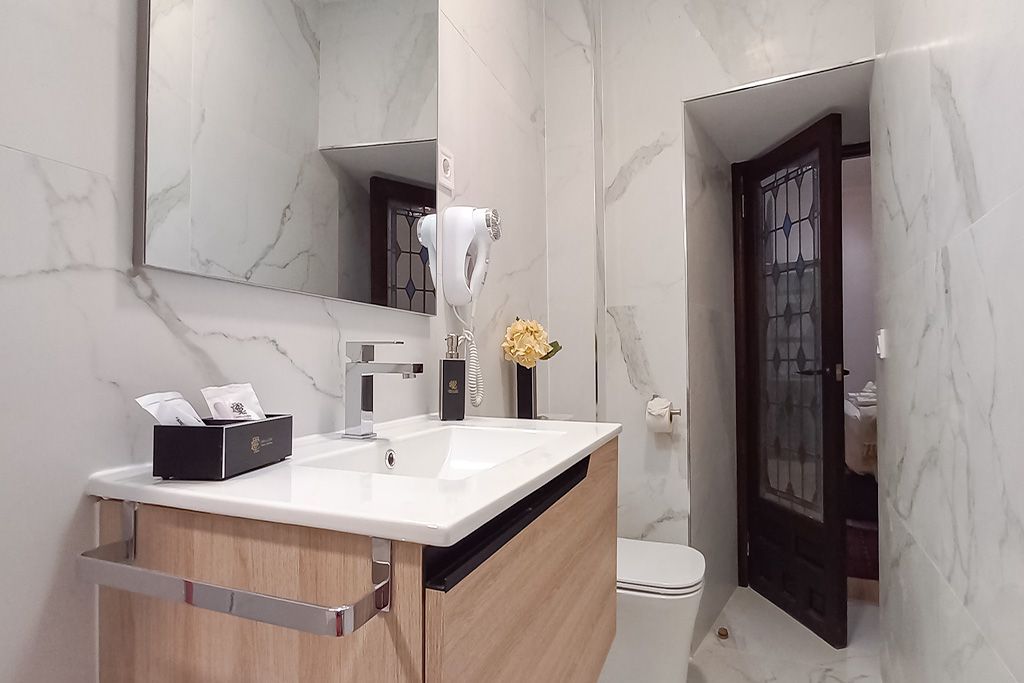 A bathroom with a sink , toilet and mirror.