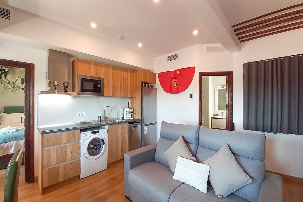 A living room with a couch and a kitchen in the background