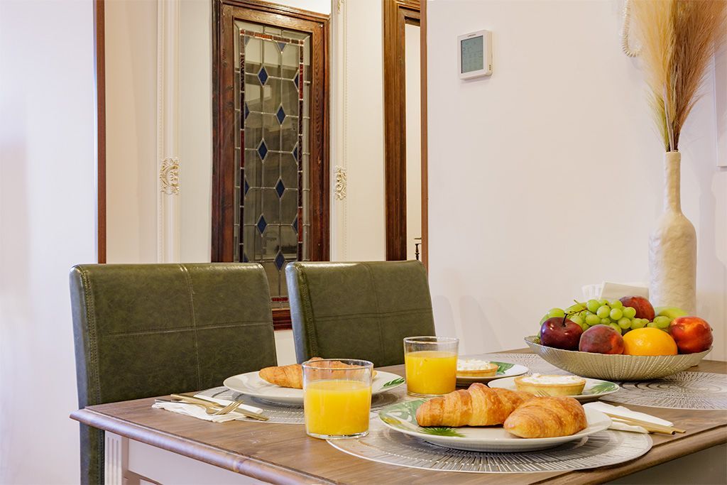 A dining room table with plates of food and glasses of orange juice.