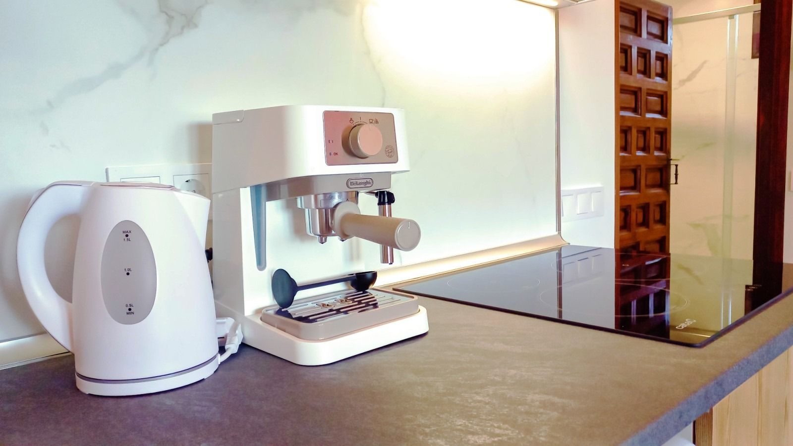 A coffee maker and a kettle are on a kitchen counter.