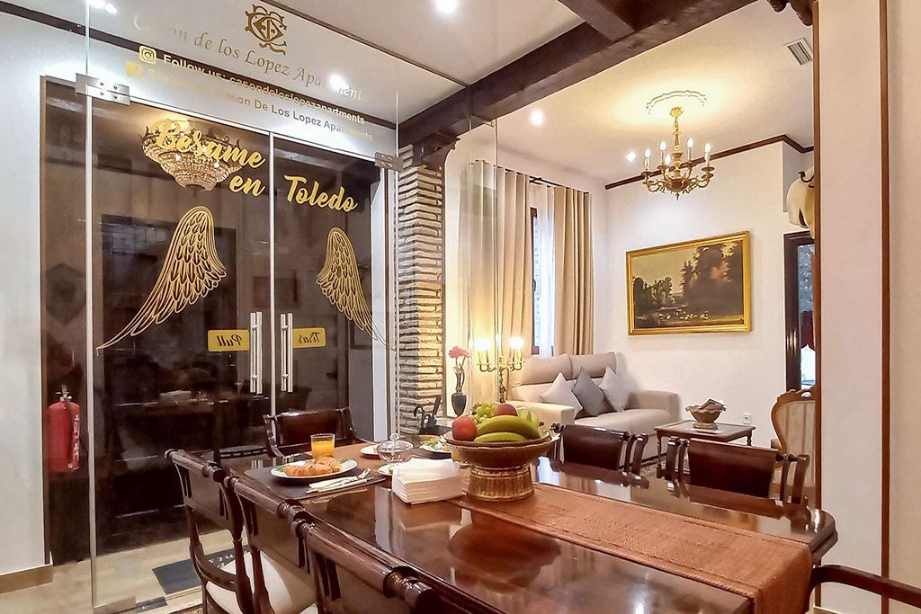 A dining room table with a bowl of fruit on it in a living room.