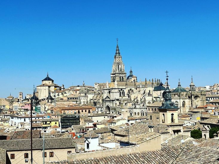 An aerial view of a city with a cathedral in the background.