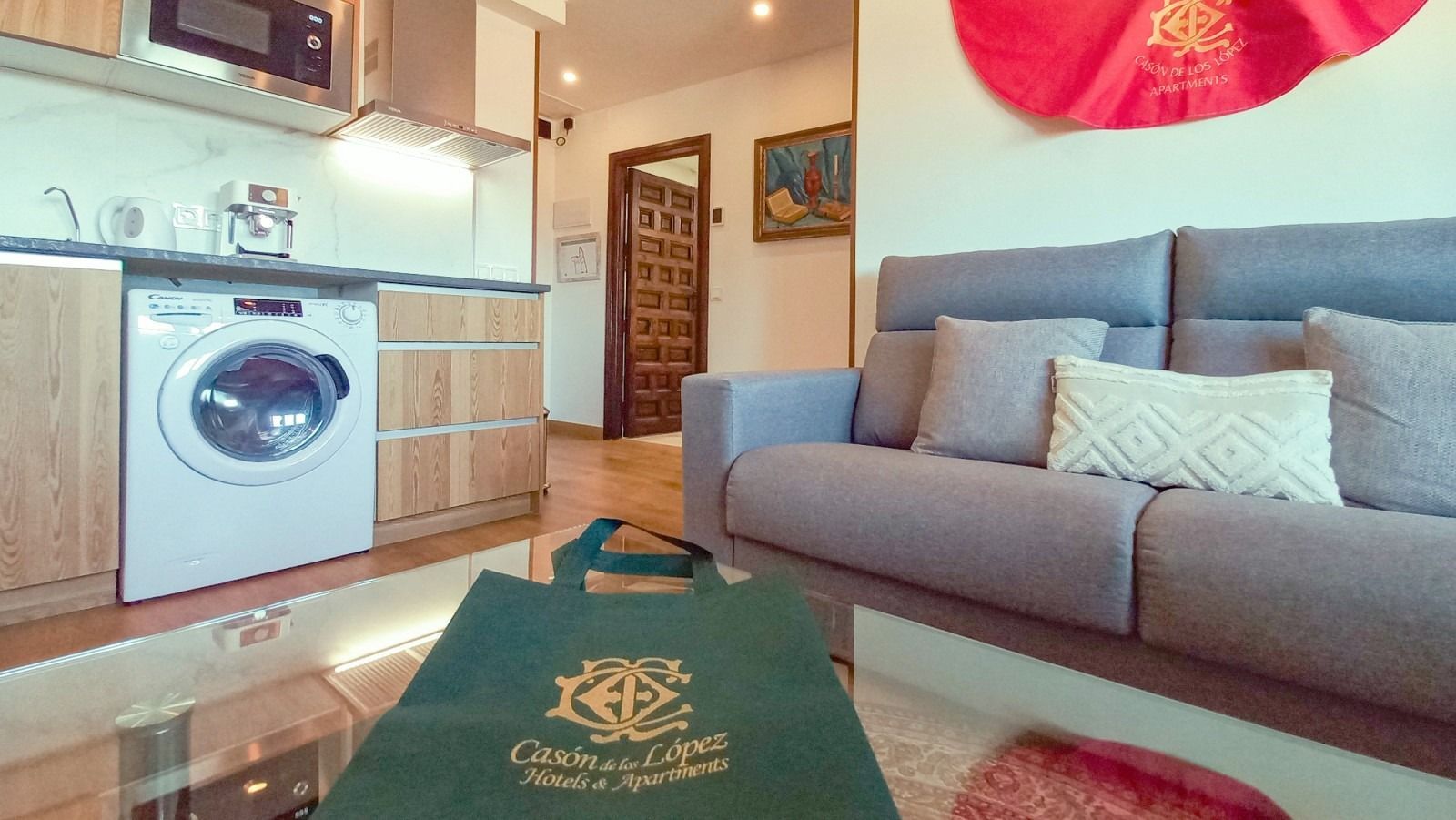 A living room with a couch , table , washer and dryer.