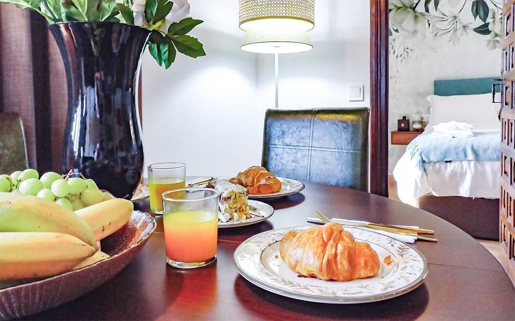 A table with plates of food and a glass of orange juice on it.