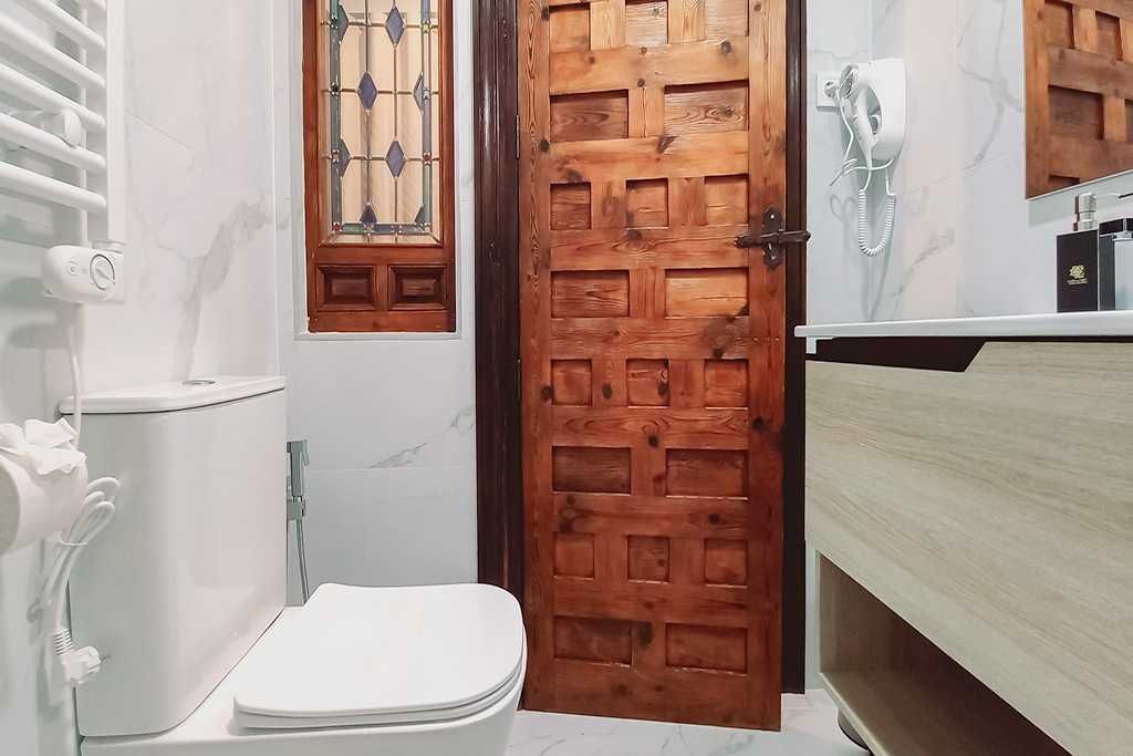 A bathroom with a toilet and a wooden door.