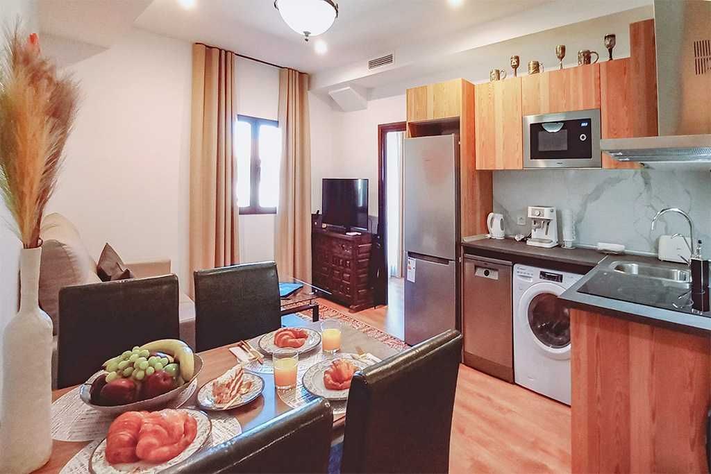 A kitchen with a table and chairs and a refrigerator.