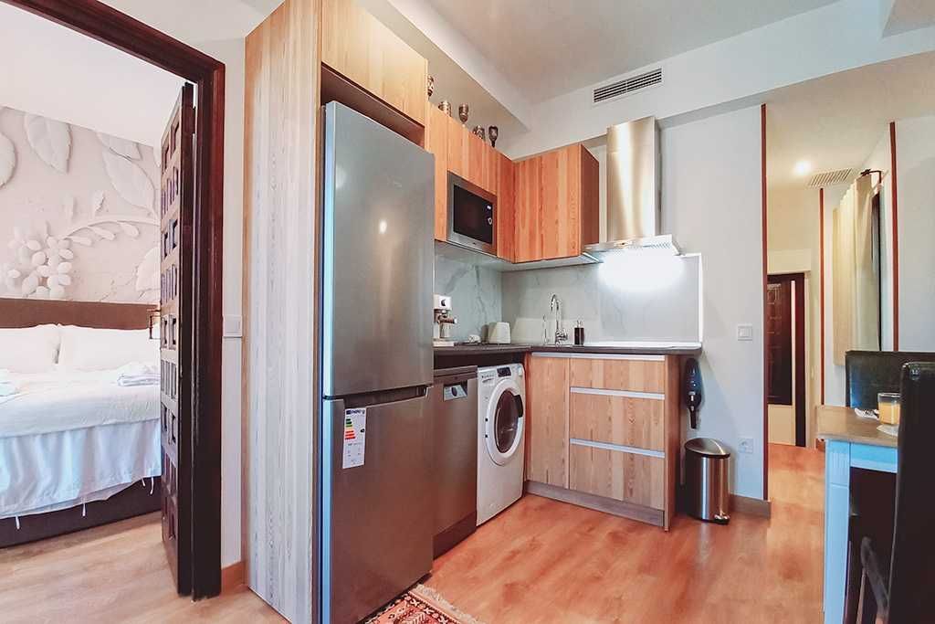 A kitchen with stainless steel appliances and wooden cabinets.