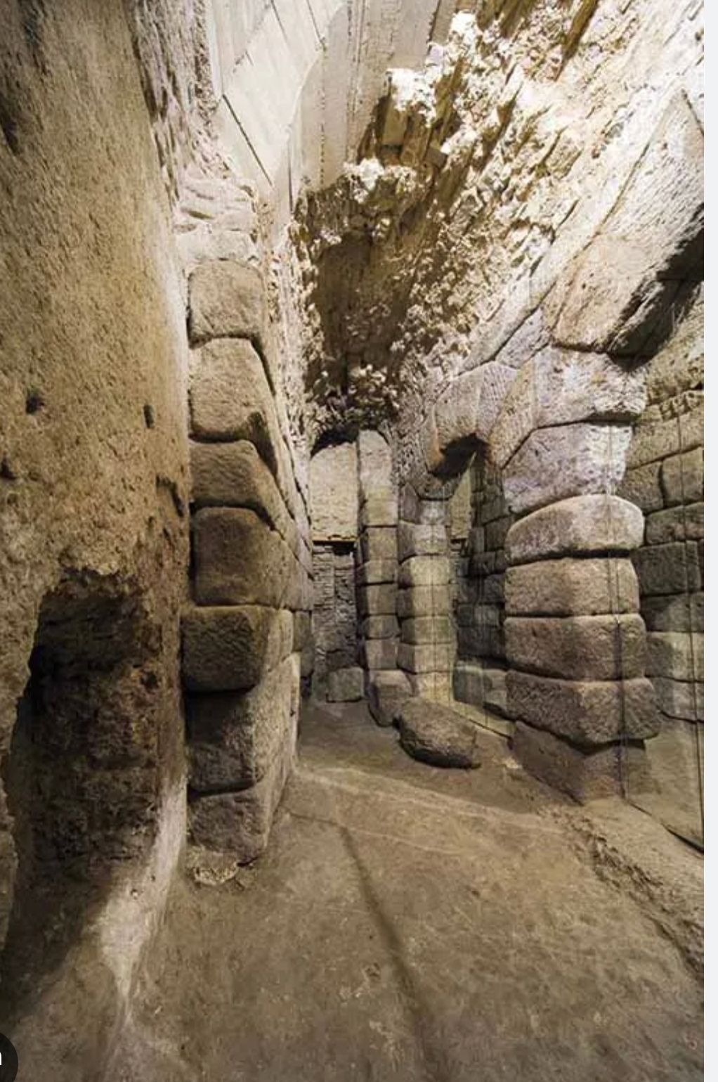 A narrow tunnel filled with rocks and bricks.