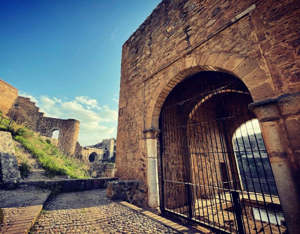 A stone archway with a gate in front of it.