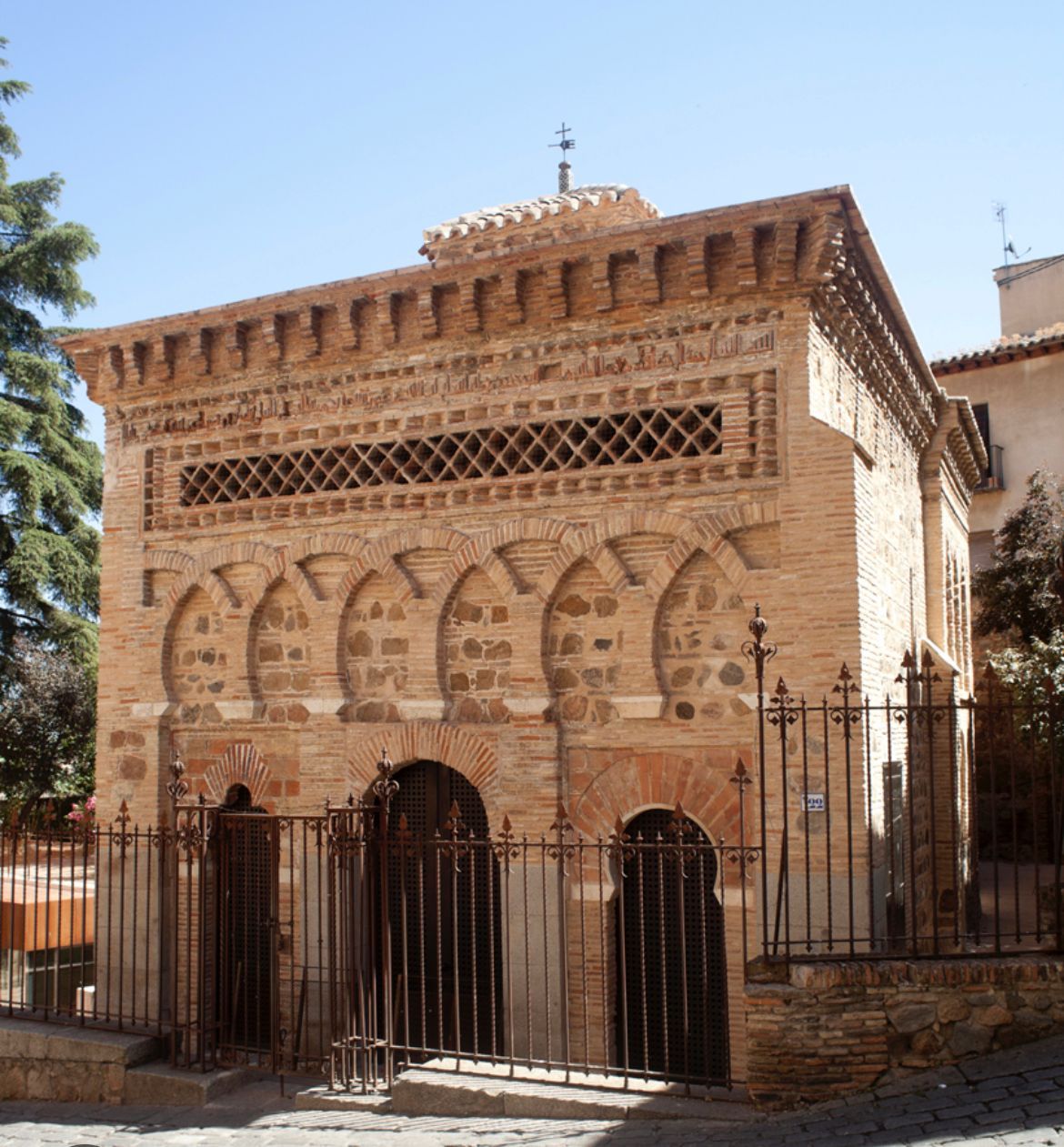 A brick building with arches and a fence around it