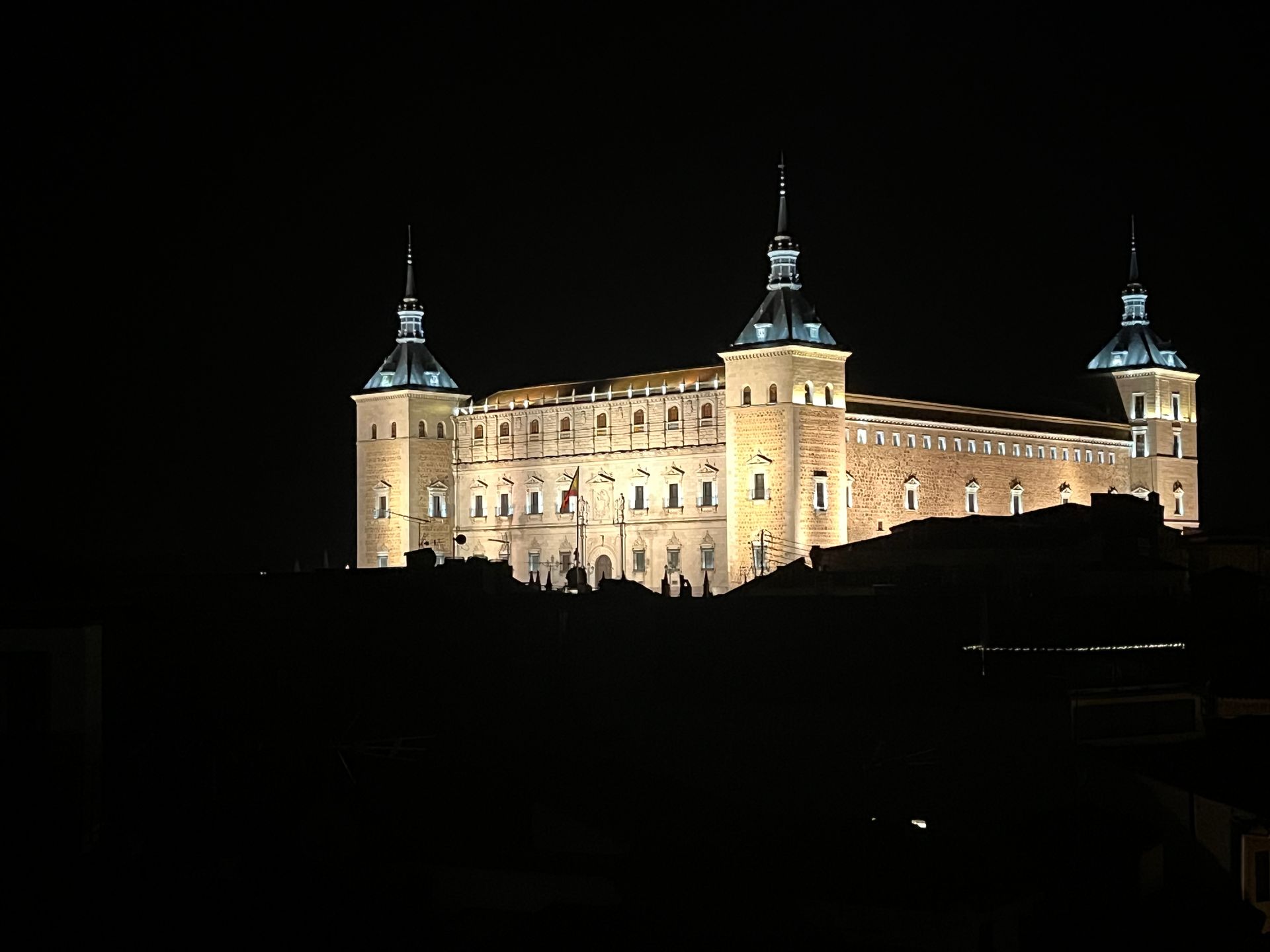 A large castle is lit up at night with two towers