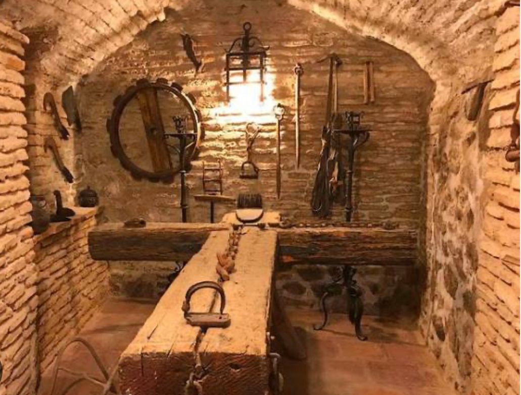 A room with a brick wall and a wooden table with tools on it.