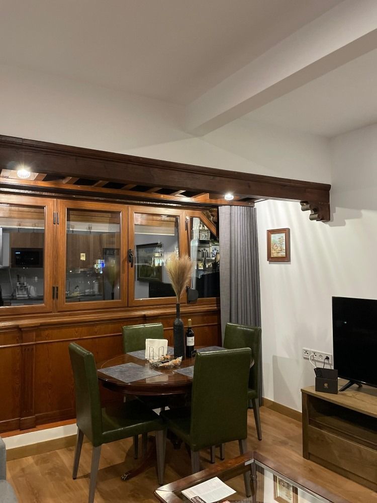 A living room with a table and chairs and a television.