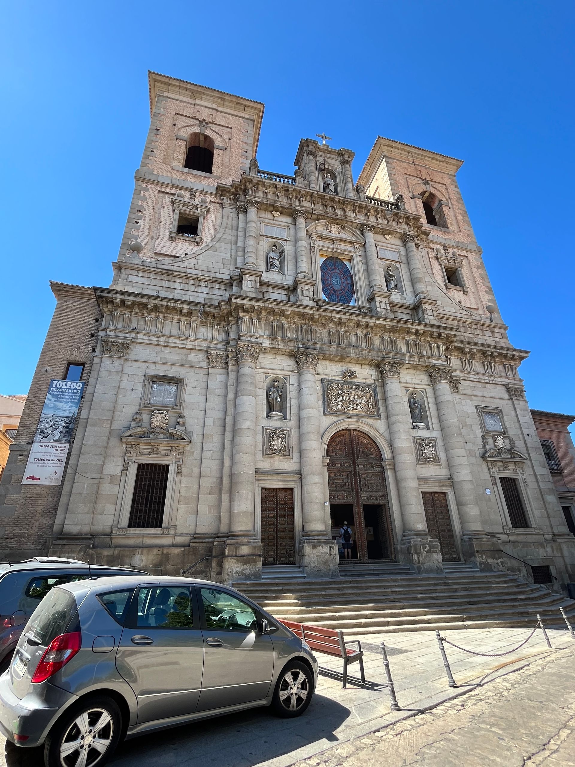 A car is parked in front of a large building.