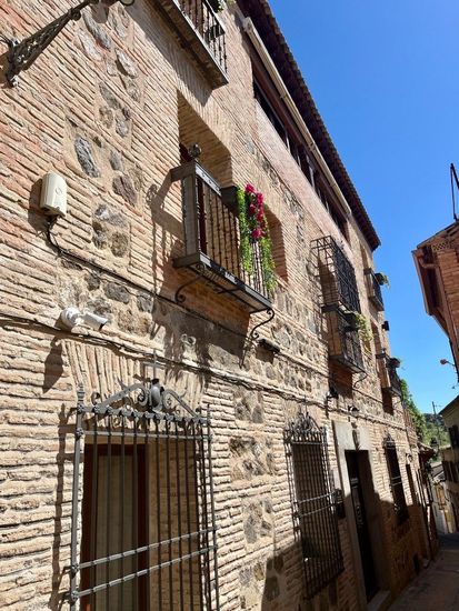 A brick building with a balcony and flowers on it.