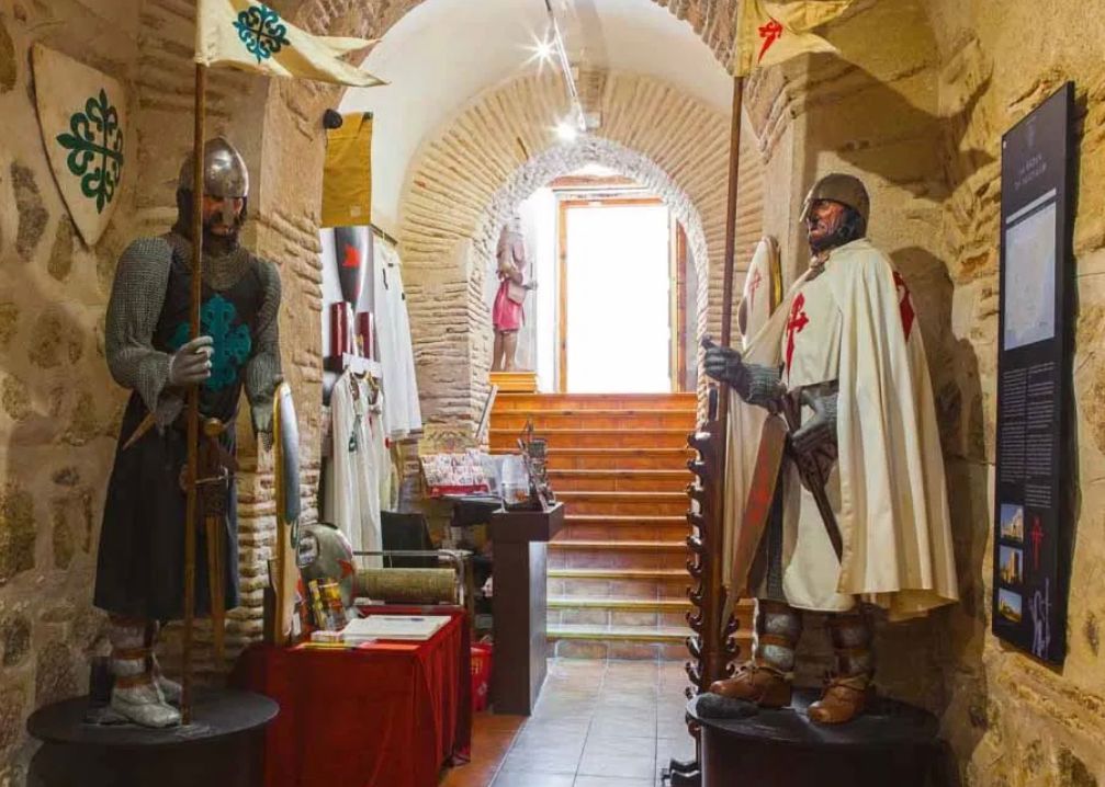 A statue of a knight holding a flag in a museum.