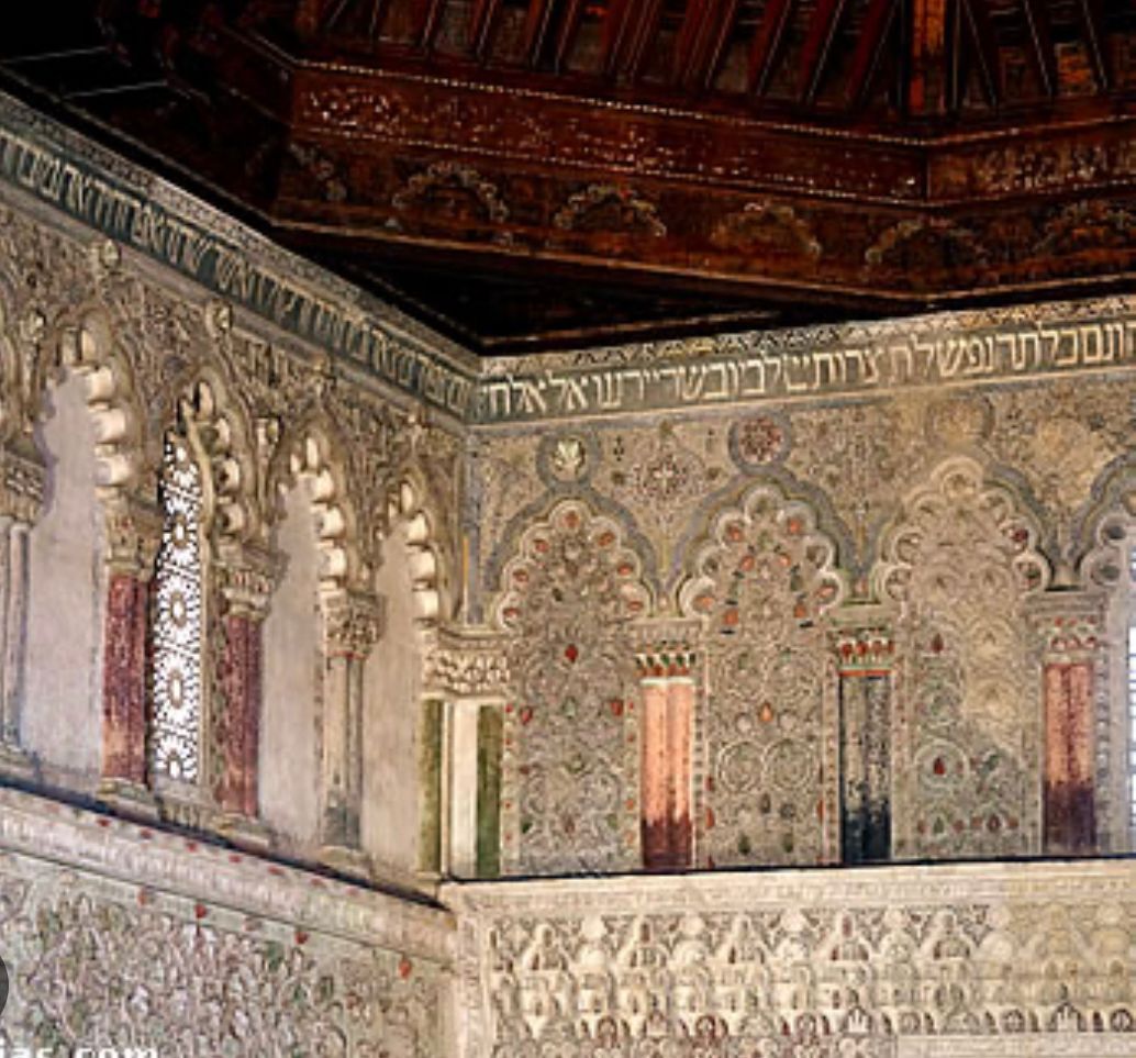 A room with a ceiling and a very ornate wall.